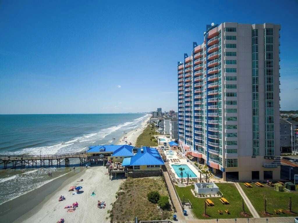 A beachfront hotel with a pool, beach access, and a pier.
