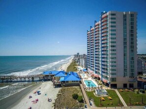 Een strandhotel met zwembad, toegang tot het strand en een pier.