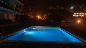 Una piscina rettangolare con un design a forma di stella al centro, circondata da un basso muro in mattoni.