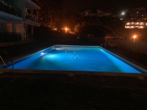 Ein rechteckiger Pool mit einem sternförmigen Design in der Mitte, umgeben von einer niedrigen Ziegelmauer.