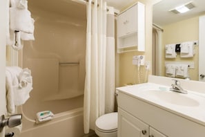 Un baño con bañera, inodoro, lavabo y toallero.