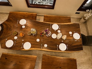 A dining table with multiple plates and cutlery, surrounded by chairs.