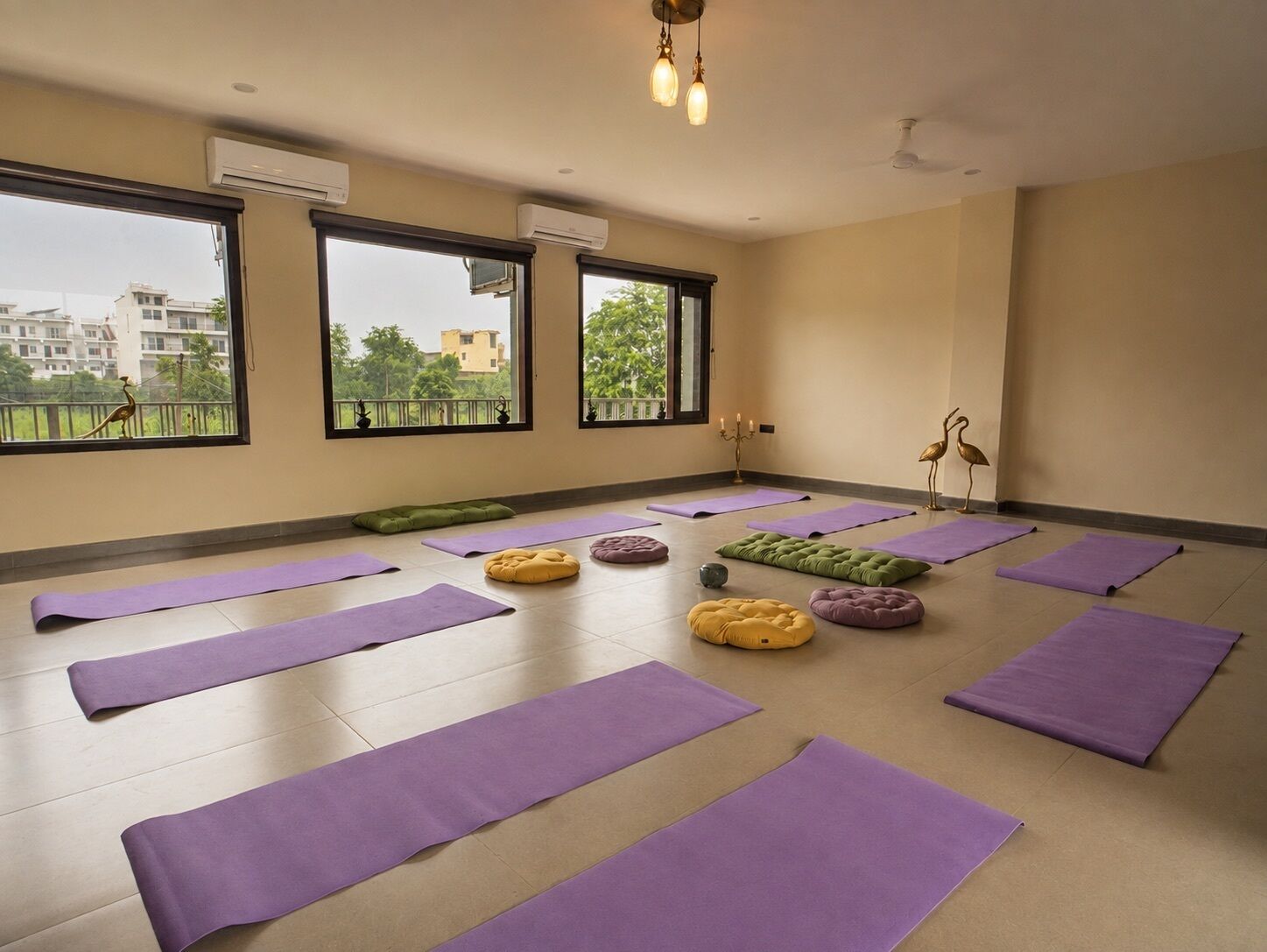 Une salle de yoga équipée de plusieurs tapis, d’un coussin vert et d’une statuette d’oiseau décorative.