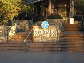 Un escalier en pierre mène à un bâtiment sur lequel est apposée une enseigne indiquant le « Lake Tahoe Resort Hotel ».