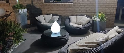 Een terras met rieten meubels en plantenpotten.
