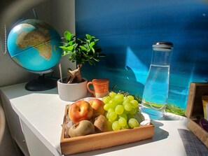 A desk with a globe, a potted plant, a water bottle, and a fruit tray. - Welcome to a haven of tranquility in Zuydcoote (Zuydcoote)