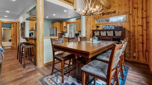 A spacious wooden interior with a dining area, kitchen, and a staircase.