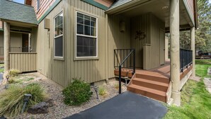 A two-story house with a covered porch, a front door, and a staircase leading to the entrance.