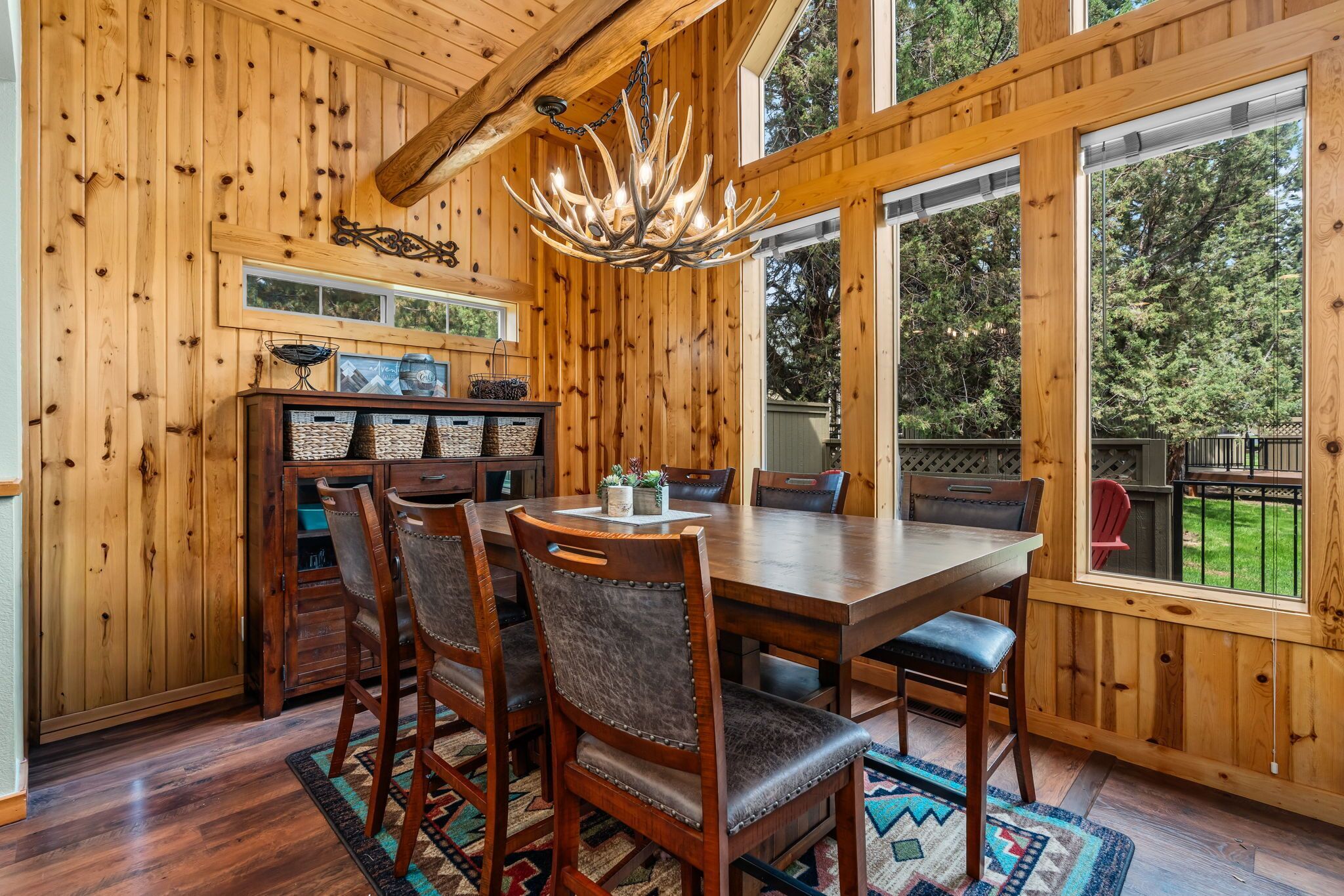 Un intérieur en bois comprenant une table à manger, des chaises et un lustre.