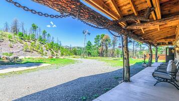A covered outdoor seating area with a gravel path leading to a wooden structure.