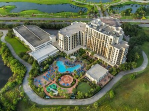 An aerial view of a hotel with multiple buildings, a swimming pool, and landscaped gardens. - 2 bedroom at Las Palmeras for EDC Orlando (Orlando)