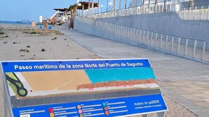 En strandpromenad med en informationsskylt.