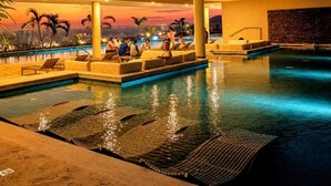 Ein Poolbereich mit Liegestühlen und Blick auf den Sonnenuntergang.