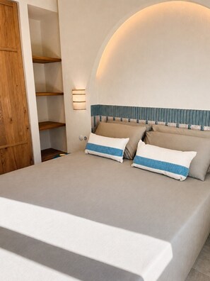 Ein Schlafzimmer mit einem großen Bett, Holzregalen und einer Wandleuchte.
