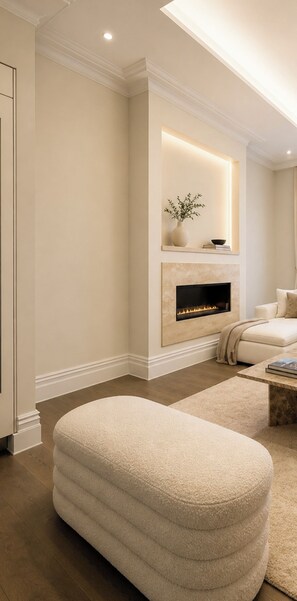 Ein modernes Wohnzimmer mit Kamin, einer Couch und einem großen Pouf.