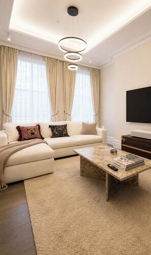 Ein modernes Wohnzimmer mit einer Couch, einem Couchtisch und einem Flachbildfernseher.