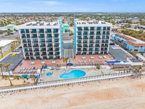 Um hotel com vários andares, piscina e vista para os arredores.