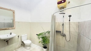 A bathroom with a sink, toilet, shower, and a potted plant. - Pondok Cintya Kerobokan Canggu (Badung)