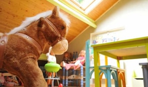 A room with a wooden ceiling, a green table, and a chair. - Le Chênelierre - Everything for the Kids - Dogs Welcome (Free) (Manhay)
