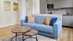 A modern living room with a sofa, two coffee tables, and a kitchen in the background. - Casa e Appartamento Vacanze Gallese 8 (Roma)