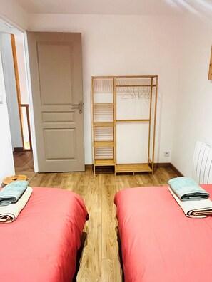 A room with two beds, a wardrobe, and a door. - Our traditional house with a courtyard, 3 km from the sea   (Carneville)