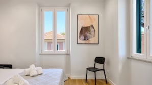 Une chambre à coucher avec un lit, une chaise, une fenêtre et un tableau.