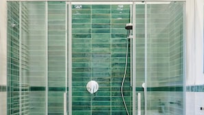 Une salle de bain moderne avec une douche à parois de verre, une baignoire blanche et un lavabo blanc.
