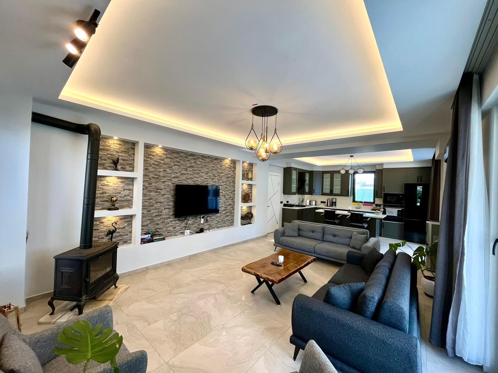 A modern living room with a flat-screen TV, a fireplace, a sofa, and a coffee table.