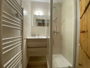 A bathroom with a shower, a sink, and a mirror. - Cozy apartment - 4 guests at the foot of the slopes (Arêches-Beaufort)