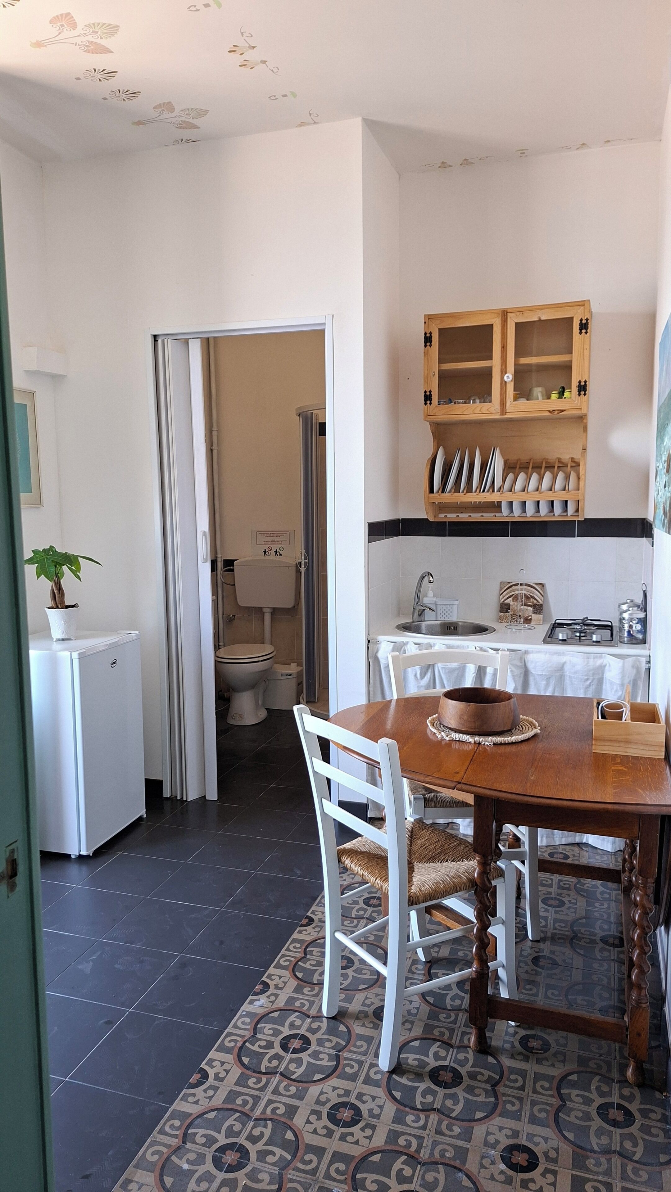 A compact kitchen with a dining area, a sink, and a cabinet above the counter.