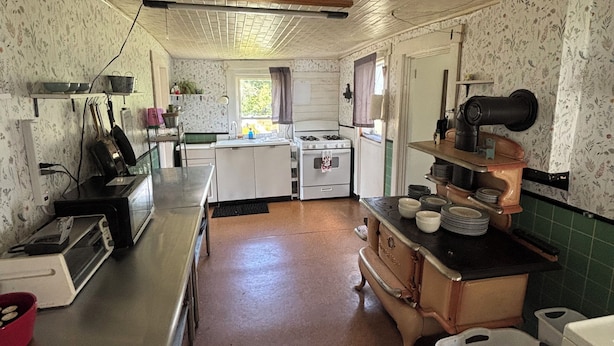 A kitchen with a stove, sink, and various appliances.