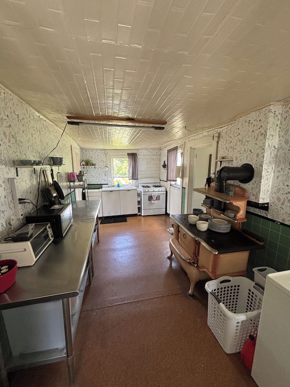A kitchen with a stove, sink, and various appliances. - Unplug at Gentle Giant Acres — Historic Maine Farmhouse on 16 Acres (Kingman)