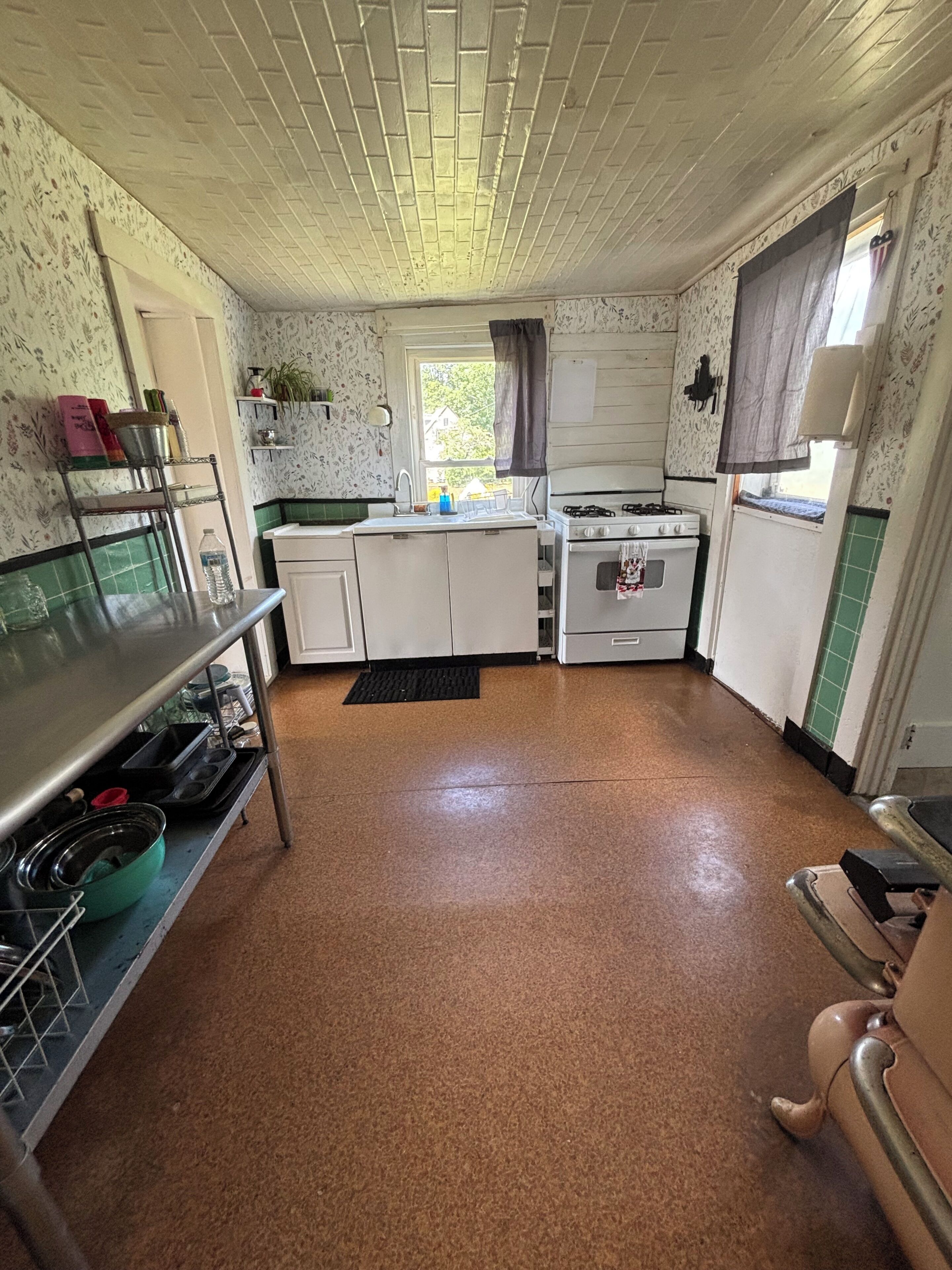 A compact kitchen with a sink, stove, and cabinets.
