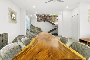 Ein moderner Konferenzraum mit einem langen Holztisch, bequemen Stühlen, einer Treppe und Blick auf eine felsige Landschaft.