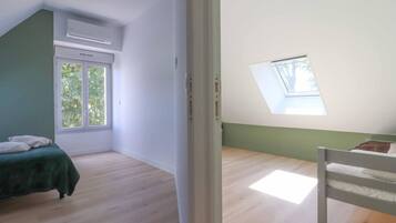 Een kamer met een bed, een dakraam en een raam.