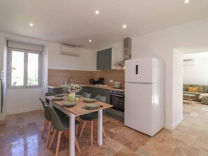Une cuisine moderne équipée d’une table à manger pour quatre personnes, d’un réfrigérateur et d’une cuisinière.