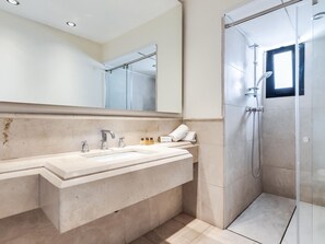 A modern bathroom with a large mirror, a sink with two faucets, and a shower area. - Apartment in the heart of Puerto Banús - 4 guests (Marbella)