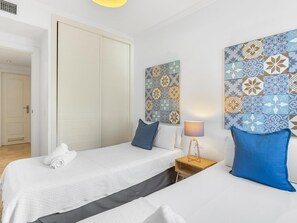 A hotel room with a bed, a bedside table, a lamp, and a wall with patterned tiles. - Comfortable apartment, pets welcome, ideal location (Marbella)