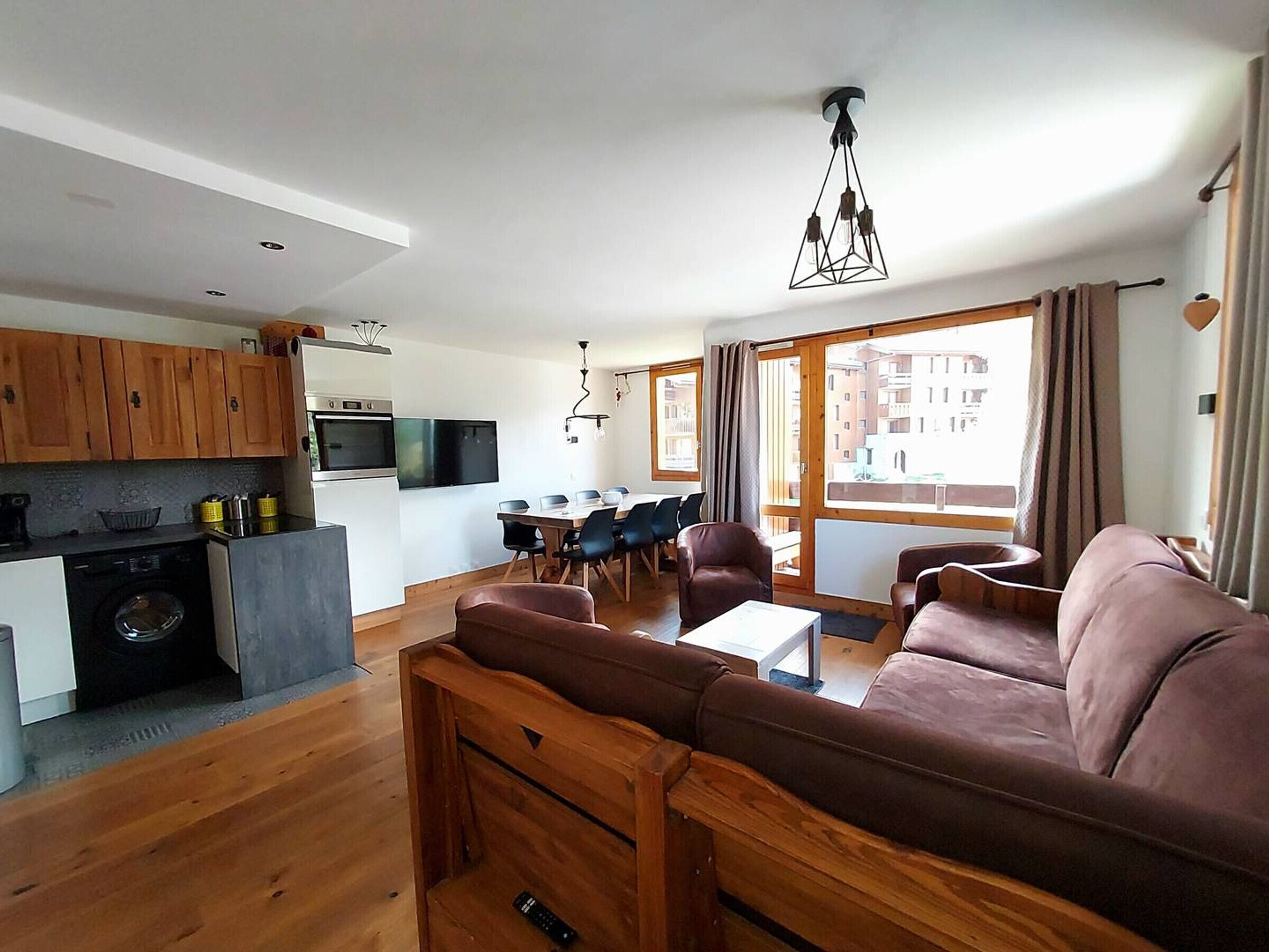 A modern living space with a kitchen, dining area, and seating area.