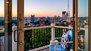 Ein Balkon mit Blick auf die Stadt im Abendrot.
