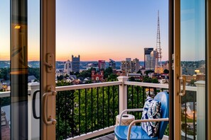 Ein Balkon mit Blick auf die Stadt im Abendrot.