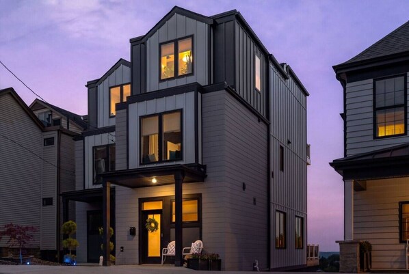 A modern two-story house with a covered porch and a visible front door. - Premium Mt. Washington Retreat: VIP Views, Hot Tub, Garage (Pittsburgh)