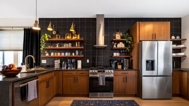 Eine moderne Küche mit Holzschränken, einem Edelstahlkühlschrank und einem Gasherd.