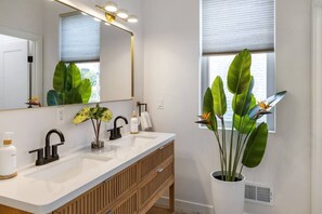 A modern bathroom with two sinks, a large mirror, and a potted plant. - Premium Mt. Washington Retreat: VIP Views, Hot Tub, Garage (Pittsburgh)