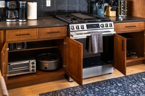 A kitchen with a built-in oven, a coffee maker, and a crockpot. - Premium Mt. Washington Retreat: VIP Views, Hot Tub, Garage (Pittsburgh)