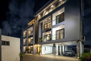 Ein mehrstöckiges Hotel mit überdachter Einfahrt und einem Auto auf der Auffahrt.