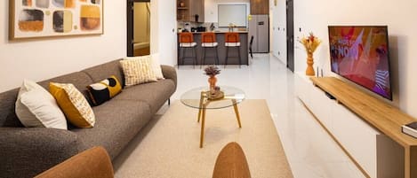 Uma sala de estar moderna com um sofá, uma mesa de centro e uma televisão.