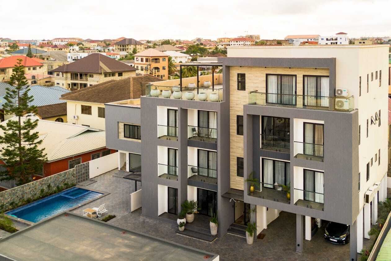 A multi-story building with a rooftop pool and outdoor seating area.