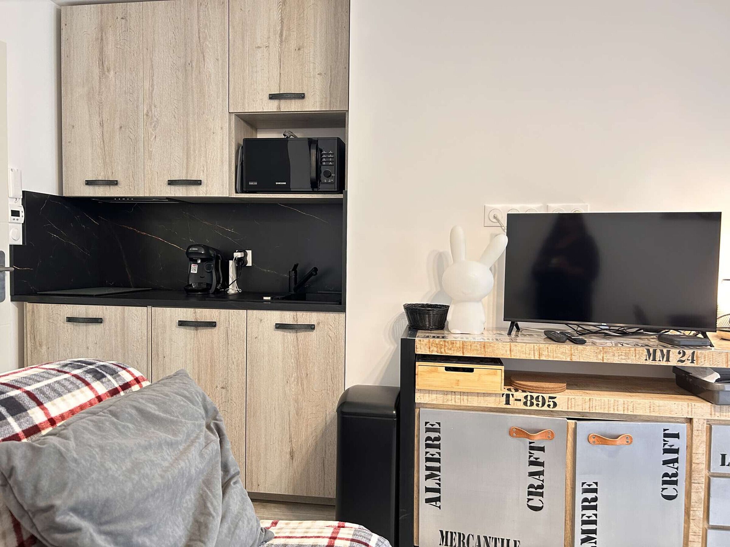 A modern kitchen with a black countertop, a microwave, and a coffee machine.