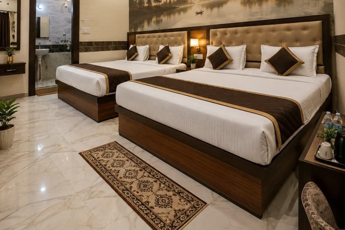 Habitación de hotel con una cama grande, baño con espejo y un mural decorativo en la pared.